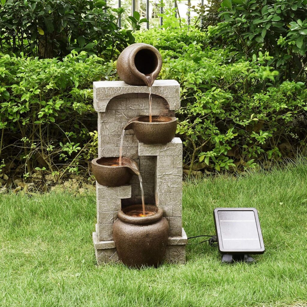 Solar powered tiered pot garden fountain with cascading water over stone-look columns on a small lawn.